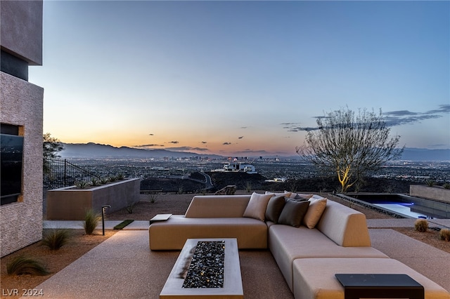 patio terrace at dusk featuring an outdoor living space with a fire pit