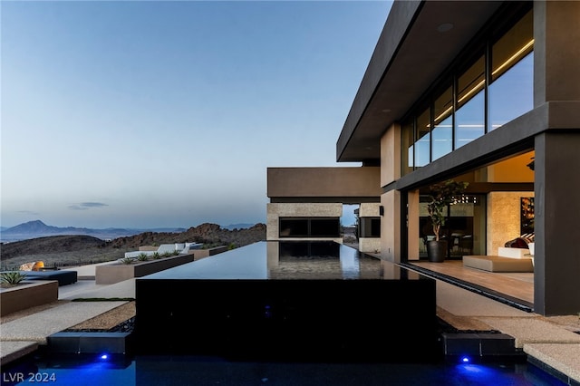 patio terrace at dusk featuring a mountain view