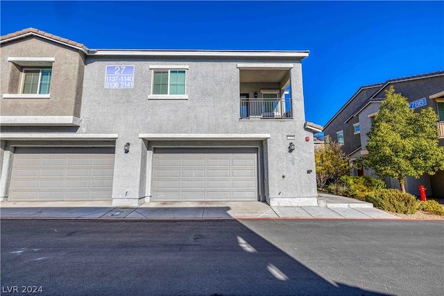 multi unit property featuring a garage and a balcony