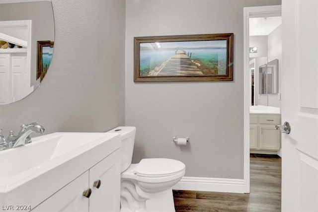 bathroom featuring wood-type flooring, vanity, and toilet