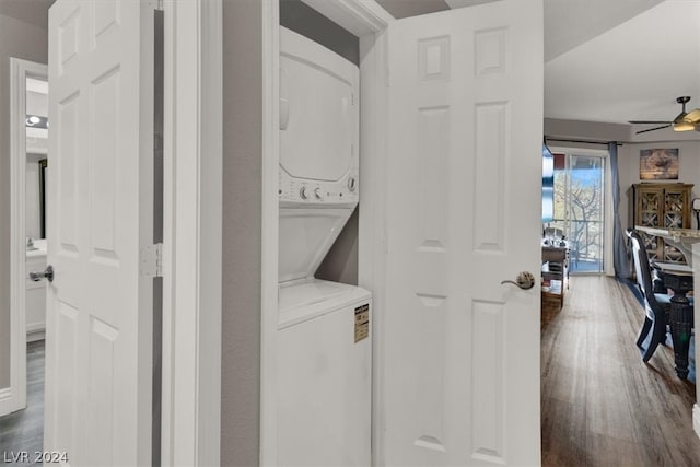 clothes washing area featuring ceiling fan, dark hardwood / wood-style floors, and stacked washer / drying machine