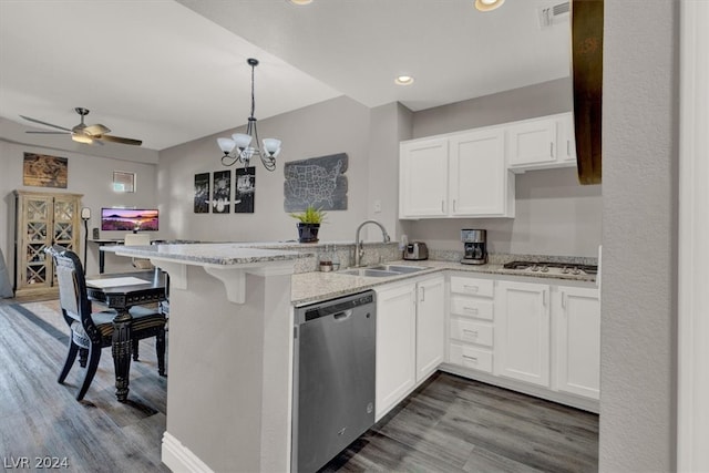 kitchen featuring ceiling fan with notable chandelier, decorative light fixtures, stainless steel appliances, kitchen peninsula, and hardwood / wood-style flooring