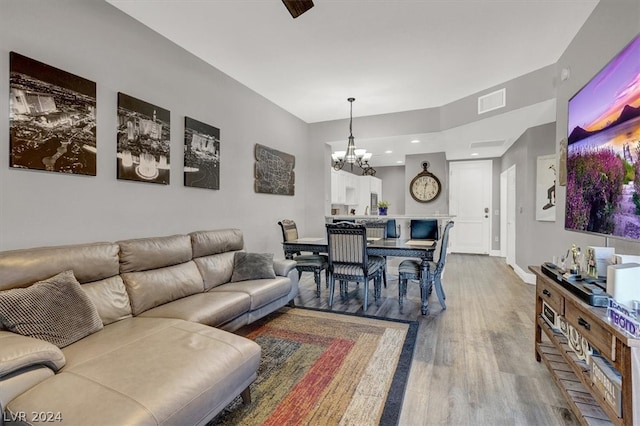 living room with hardwood / wood-style floors and a notable chandelier