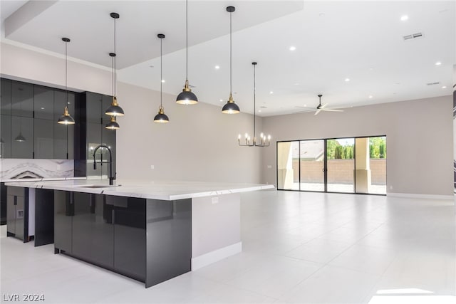 kitchen featuring a large island, sink, decorative light fixtures, backsplash, and ceiling fan with notable chandelier