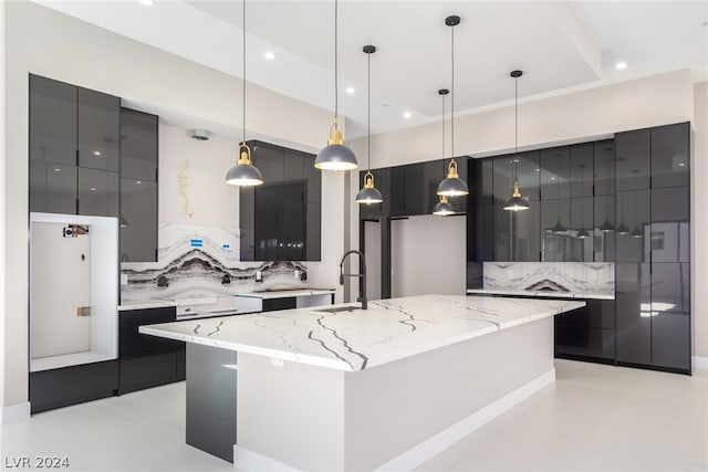 kitchen with decorative light fixtures, a spacious island, sink, and tasteful backsplash