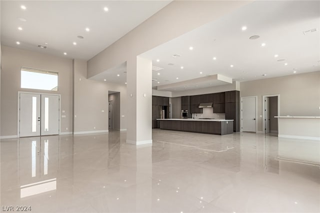 interior space with a high ceiling and light tile floors