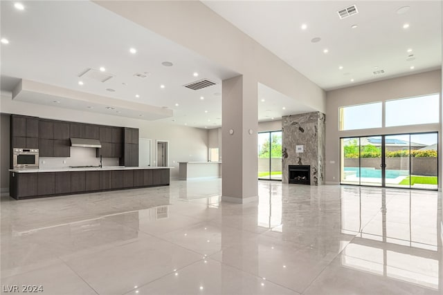 interior space featuring a large fireplace and light tile flooring