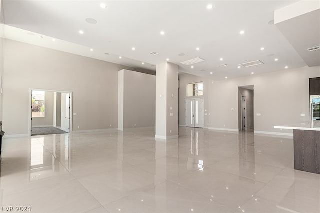 unfurnished room with a high ceiling and light tile floors