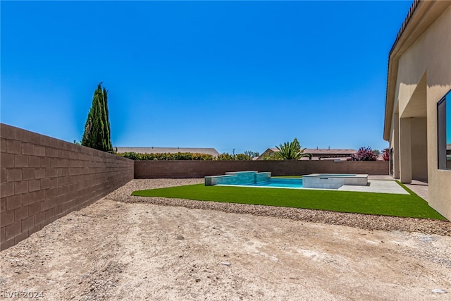 view of yard featuring a patio and a swimming pool with hot tub