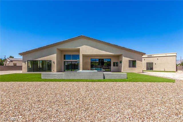 rear view of property featuring a patio area and a lawn