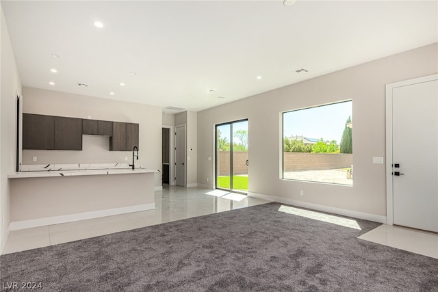 unfurnished living room with sink and light tile floors