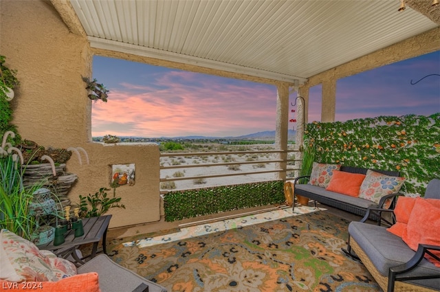 patio terrace at dusk featuring a balcony