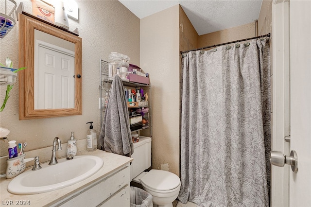 bathroom with toilet, vanity, and a textured ceiling