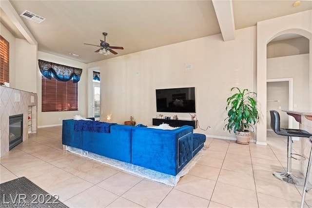 tiled living room featuring ceiling fan and beam ceiling