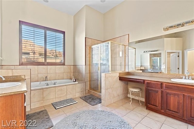 bathroom featuring plus walk in shower, vanity, and tile flooring