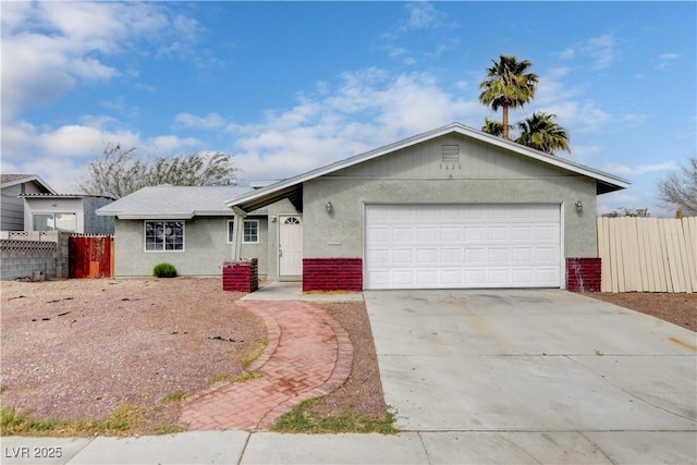 ranch-style home featuring brick siding, fence, stucco siding, a garage, and driveway