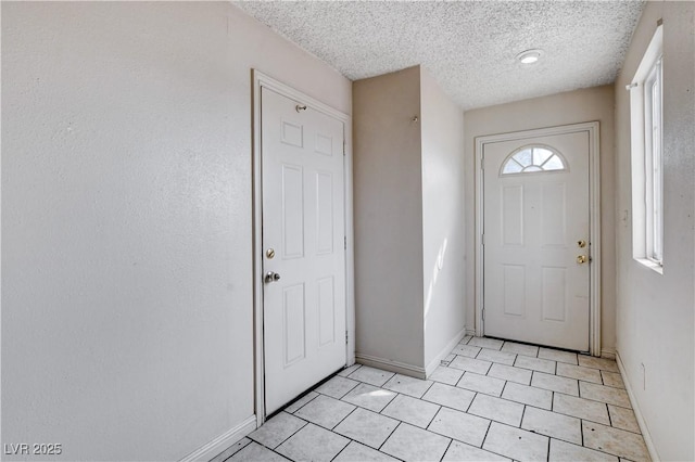 entrance foyer with baseboards and a textured ceiling