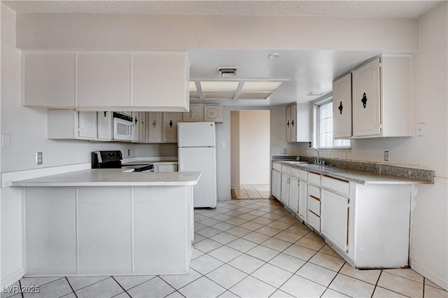 kitchen featuring white appliances, light tile patterned floors, visible vents, a peninsula, and a sink