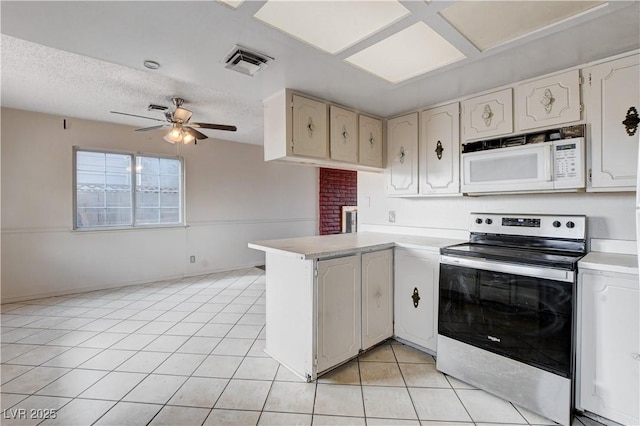 kitchen featuring white microwave, visible vents, light tile patterned floors, stainless steel electric range, and a peninsula