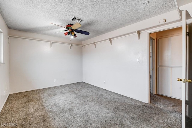 carpeted empty room featuring visible vents, a textured ceiling, and a ceiling fan