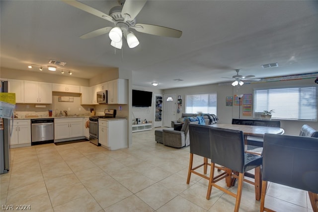 tiled dining space featuring sink, ceiling fan, and track lighting