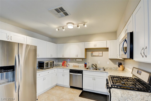 kitchen featuring rail lighting, stainless steel appliances, and white cabinets