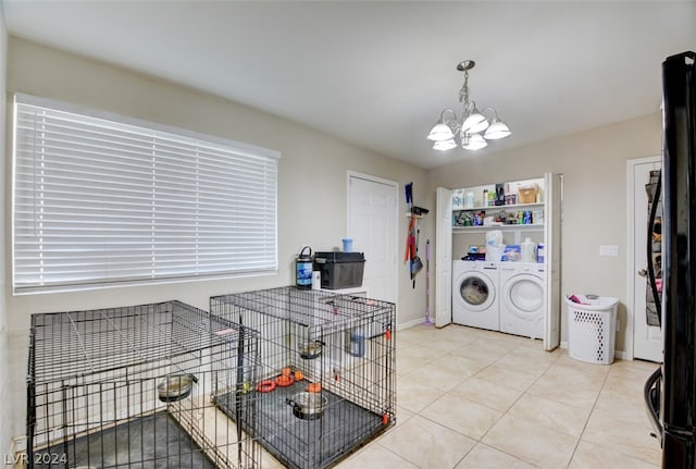 kitchen with separate washer and dryer, a chandelier, black refrigerator, pendant lighting, and light tile floors