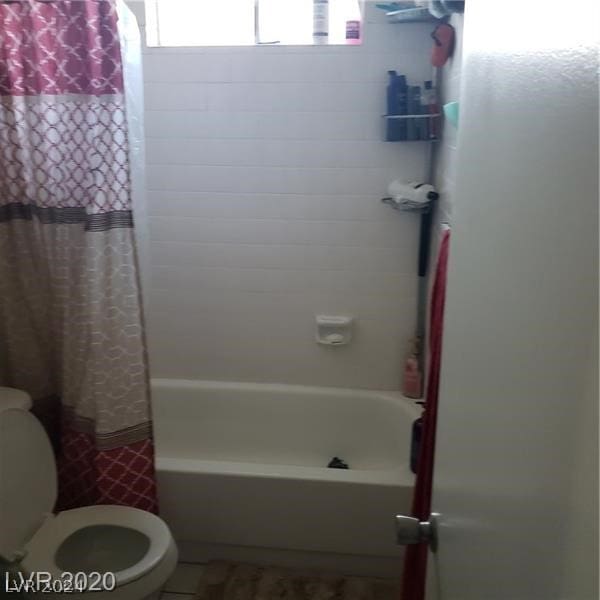 bathroom with shower / bath combination with curtain, toilet, and tile flooring