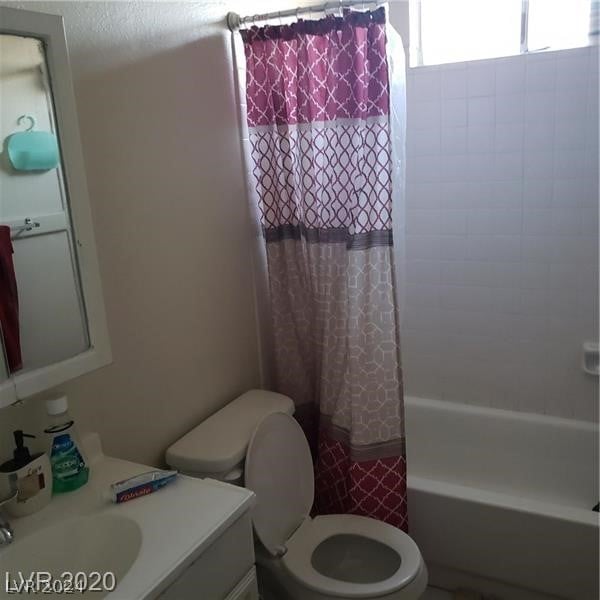 full bathroom featuring shower / bath combo, toilet, and vanity