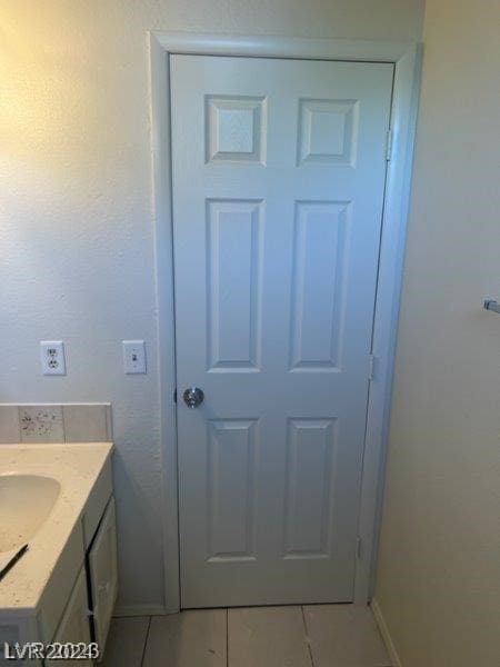 bathroom with tile flooring and vanity