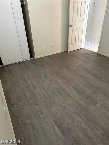 unfurnished bedroom featuring a closet and dark hardwood / wood-style floors