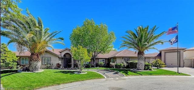 view of front facade featuring an attached garage, driveway, a front lawn, and stucco siding