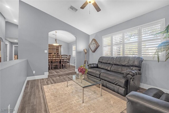 living room featuring ceiling fan, hardwood / wood-style flooring, and lofted ceiling