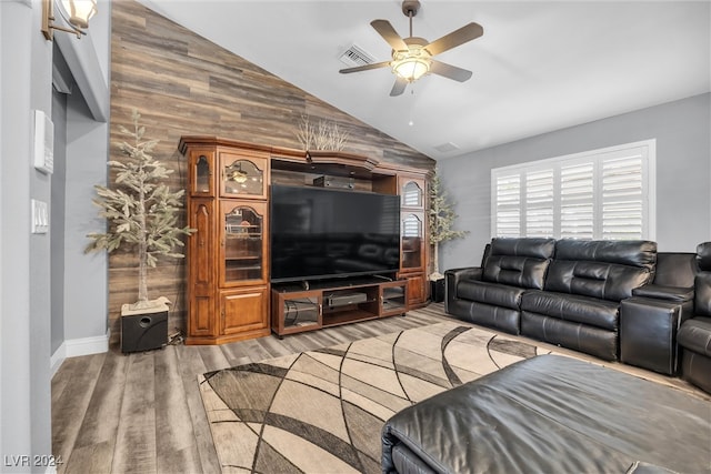 living room featuring vaulted ceiling, light hardwood / wood-style flooring, and ceiling fan