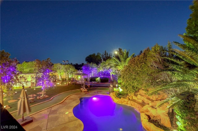 pool at night with a patio area