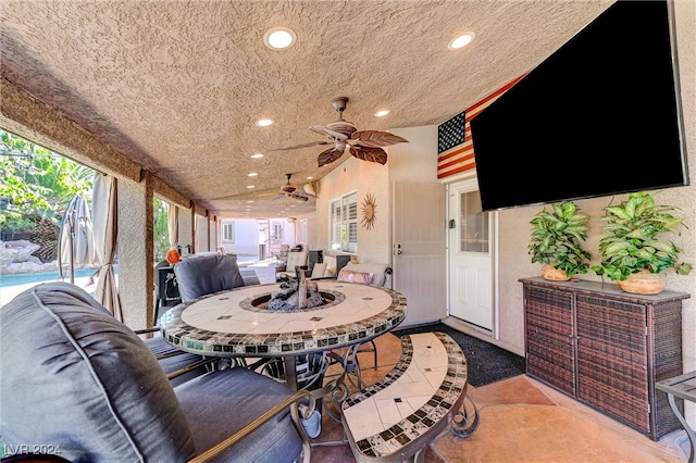 view of patio / terrace featuring ceiling fan and a pool