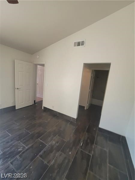 unfurnished room featuring dark wood-type flooring and vaulted ceiling