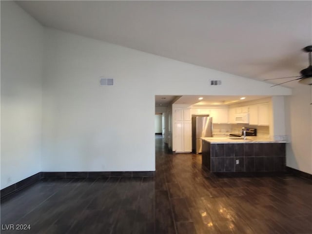 kitchen featuring stainless steel fridge, dark hardwood / wood-style flooring, white cabinetry, and kitchen peninsula