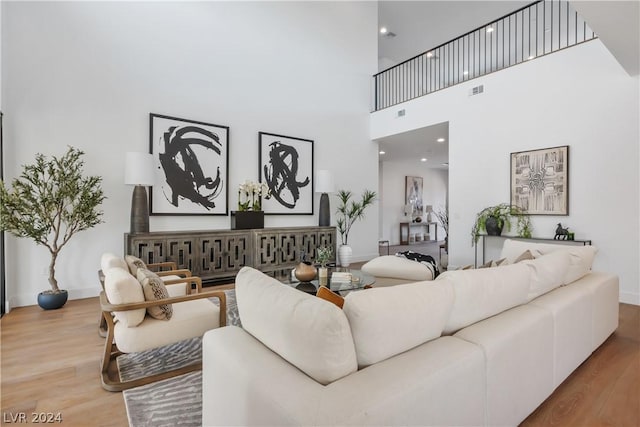 living room featuring a towering ceiling and hardwood / wood-style flooring