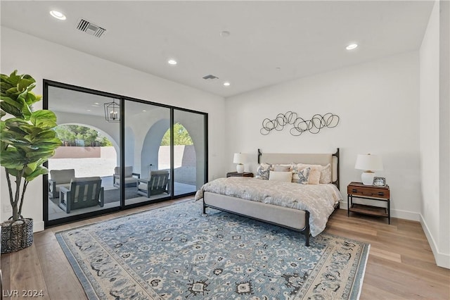 bedroom with access to exterior and light hardwood / wood-style flooring