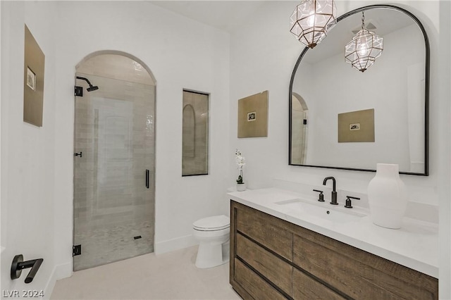 bathroom featuring a shower with door, toilet, and vanity