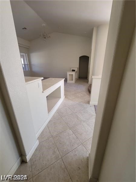 corridor featuring vaulted ceiling and tile floors