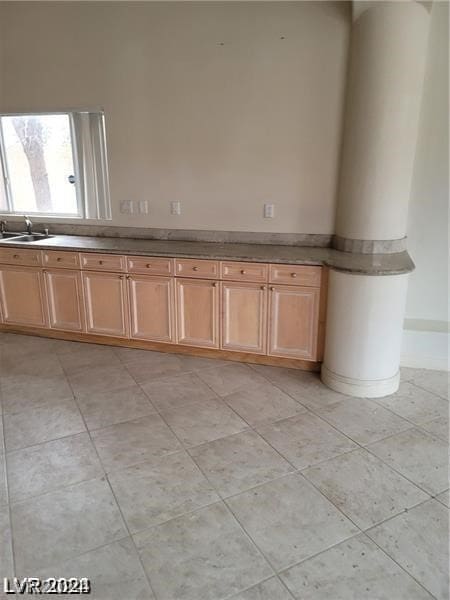 bathroom with ornate columns, tile floors, and sink