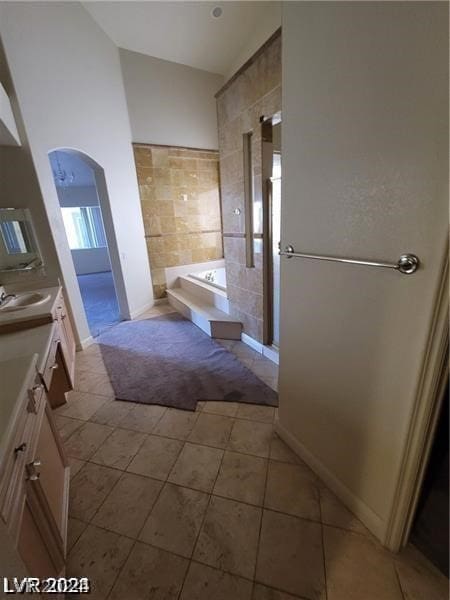 bathroom with tile floors, separate shower and tub, and large vanity