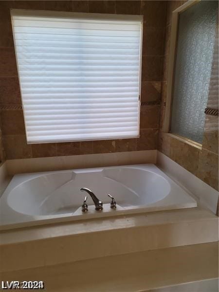 bathroom featuring tiled tub