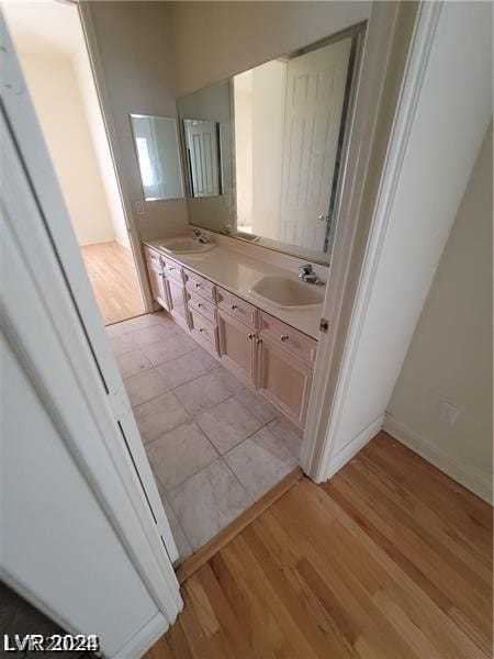 bathroom featuring hardwood / wood-style flooring and dual vanity