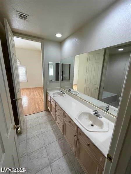 bathroom featuring oversized vanity, tile floors, and dual sinks