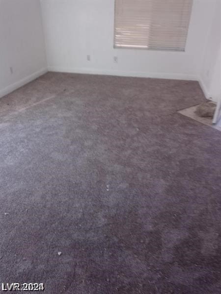 unfurnished room with dark carpet