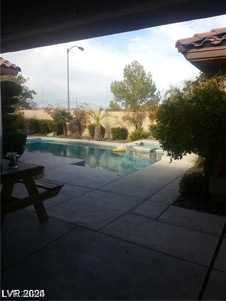 view of swimming pool with an in ground hot tub and a patio