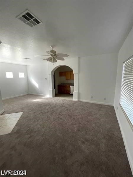 unfurnished living room featuring ceiling fan and carpet floors